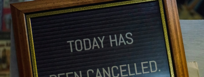 A framed sign reads "TODAY HAS BEEN CANCELLED" in white letters on a dark background.