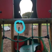 Playground climbing frame with green rope net; a broken rope is ringed in blue in the centre of the image.