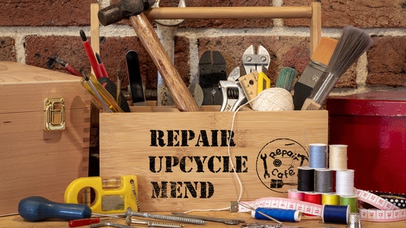 Wooden toolbox labelled "Repair Upcycle Mend" filled with tools, sewing supplies, and measuring tape.