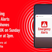 A phone displays an Emergency Alerts message; UK alert test set for 7 September at 3pm.